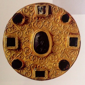 Grossa fibula rotonda con pietre incastonate ad arco finemente lavorato esposta al Museo Nazionale del Medioevo a Roma